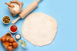 © Pixel-Shot - Raw dough and ingredients for preparing vegetable pie on blue background