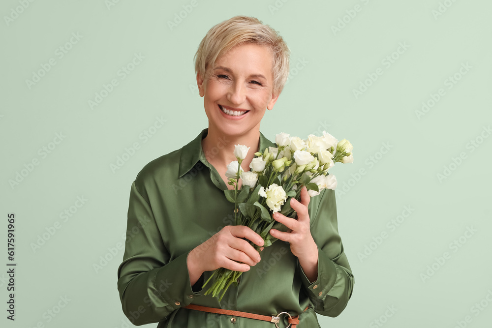 Mature woman with beautiful roses on green background