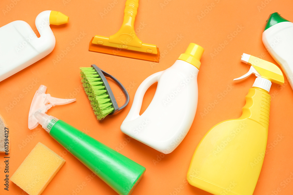 Different cleaning supplies on orange background