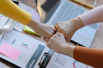 Business people shaking hands and finishing up meeting at desk in office.