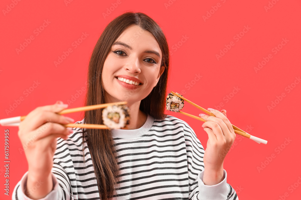 Young woman with sushi on red background
