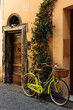 Old street in Trastevere in Rome, Italy, stylish bycice parked in front of shop entrance