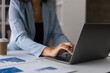 © Pichsakul - Businesswoman reading finance document to analyzing strategy of business and typing data on laptop