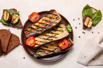 Composition with delicious grilled eggplants on light background