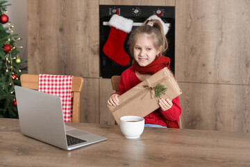 Poster - Cute little girl with Christmas gift in kitchen