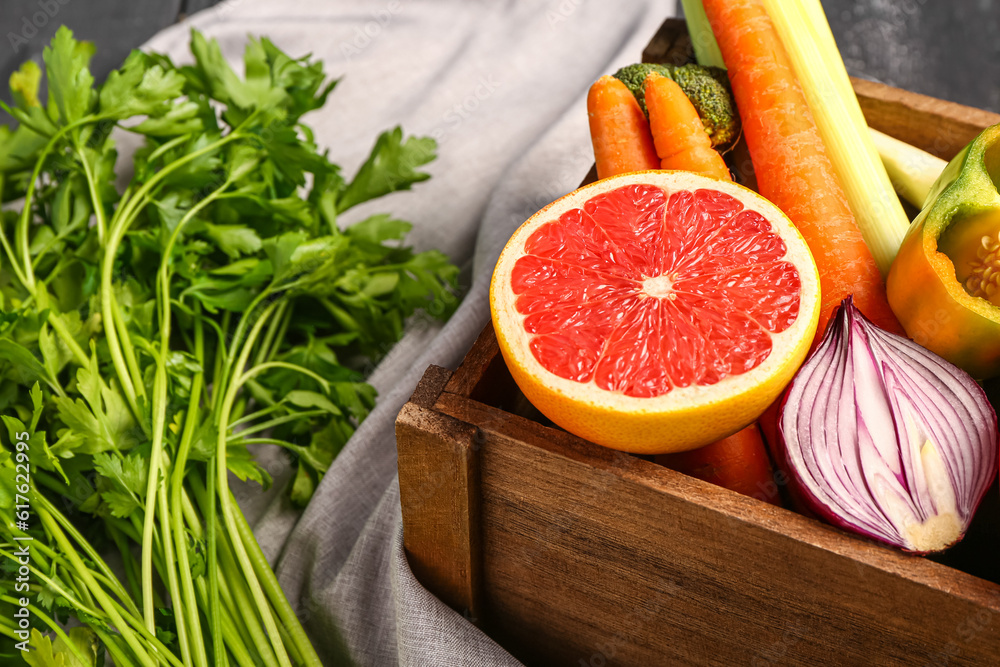 Wooden box with different fresh fruits and vegetables, closeup