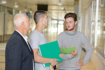 professor talking to students in corridor