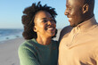 © wavebreak3 - Happy african american couple embracing on sunny beach by the sea