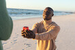 © wavebreak3 - Happy african american man kneeling with ring and proposing to girlfriend on sunny beach