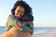 © wavebreak3 - Happy african american couple embracing and smiling on sunny beach