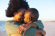 © wavebreak3 - Happy african american couple embracing and smiling on sunny beach
