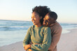© wavebreak3 - Happy african american couple embracing and smiling on sunny beach