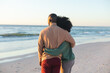 © wavebreak3 - Rear view of happy african american couple embracing on sunny beach by the sea