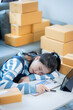 © Witoon - Startup Small Business Entrepreneur SME Asian Independent Women working with boxes at home Woman sleeping from exhaustion at work Send online e-commerce marketing boxes