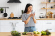 © kucherav - Young Asian woman cooking healthy food while standing in the kitchen at home. Healthy lifestyle concept