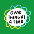 Phrase - one thing at a time. Vector hand drawn illustration on green background.