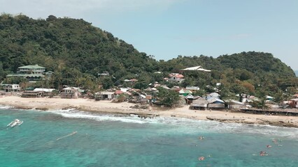 Wall Mural - Drone footage over beach with forested hills on a sunny day