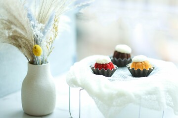 Poster - three mini cupcakes in different colors near white vase