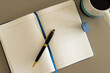 © Wavebreak Media - Overhead view of notebook, pen and cup of coffee on table
