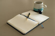 © Wavebreak Media - Close up of notebook, pen and cup of coffee on table