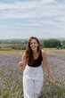 © Cady Rosenbaum/Wirestock Creators - Cheerful young female in a lavender field on a sunny day