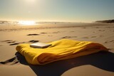 Fototapeta Tęcza - Yellow towel with pattern and book on beach, created using generative ai technology