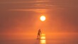 © vadimborkin - Man paddling on stand up paddle board against background of rising sun. SUP