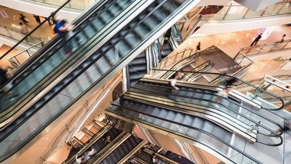 Wall Mural - Timelapse of Asian people customer transport on escalator at urban shopping mall in Hong Kong. Department store business, financial economy, Asia city life, tourist traveler lifestyle. High angle view