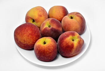 Wall Mural - Juicy peaches on a white plate. Yellow-red large ripe peaches. Juicy fruits.