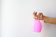 Woman hand-holding pink hygiene spray bottle.