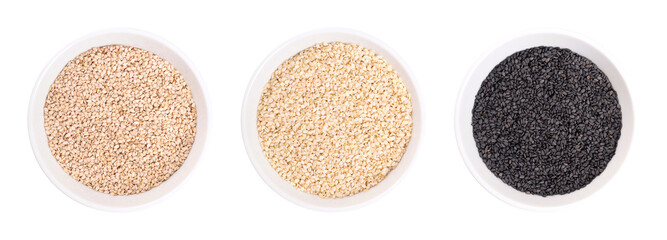 Wall Mural - Black and white sesame seeds, benne in white bowls. Unhulled and hulled white, and unhulled black seeds of Sesamum indicum, with nutty flavor, and with one of the highest oil content of any seed.