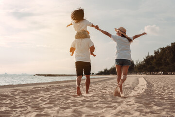 Wall Mural - Happy asian family enjoy the sea beach. father, mother and daughter having fun playing beach in summer vacation on the ocean beach. Happy family with vacation time lifestyle concept.