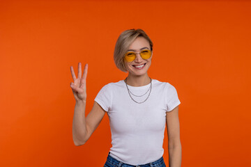 Wall Mural - Delighted woman in white t shirt showing three fingers