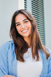© Jose Calsina - Vertical portrait of a joyful and adorable teenage brunette woman posing for a college promotion with crossed arms. Happy caucasian young student female looking at camera with a perfect white teeth