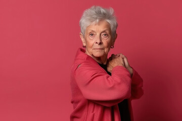 senior woman on a red coat posing in front a red background
