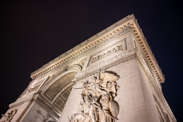 Wall Mural - Detailed view of Arc de Triomphe from bottom by night, Paris, France