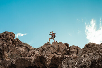 Wall Mural - adventure seeker on majestic mountain peak looking out into the distance