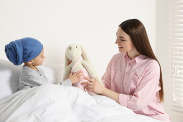 Canvas Print - Childhood cancer. Mother and daughter with toy bunny in hospital