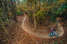A Mountain Biker Zooms Around A Curving Singletrack Trail In A North Carolina Forest In Autumn
