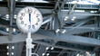 White contemporary analog clock on CCTV pillar in airport terminal. Time instrument in public transportation building