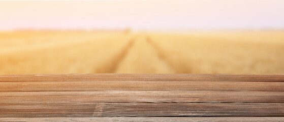 Wall Mural - Empty wooden table in golden wheat field