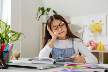 Canvas Print - Little girl reading schoolbook at home