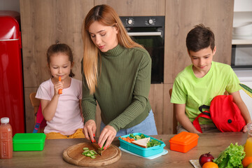 Canvas Print - Mother preparing school lunch for her little children in kitchen