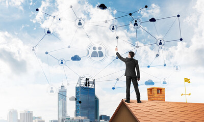 Wall Mural - Businessman on house roof presenting networking and connection concept. Mixed media