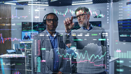 multiracial financial analysts look on computer generated virtual 3d real-time stocks on glass wall,