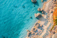 Top View Of Beach Chairs By Turquoise Sea In Greece
