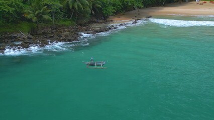 Sticker - Aerial of a person on a small canoe boat sailing on the waters of sea in Tallala Beach, Sri Lanka