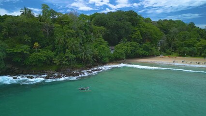 Canvas Print - Aerial of a person on a small canoe boat sailing on the waters of sea in Tallala Beach, Sri Lanka