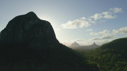 Canvas Print - Landscape view of sunny green hills range of Glass House Mountains with cloudy sky in Australia