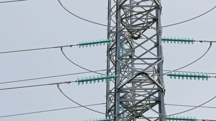 Canvas Print - Big transmission towers with electric wires standing against the gray daytime sky